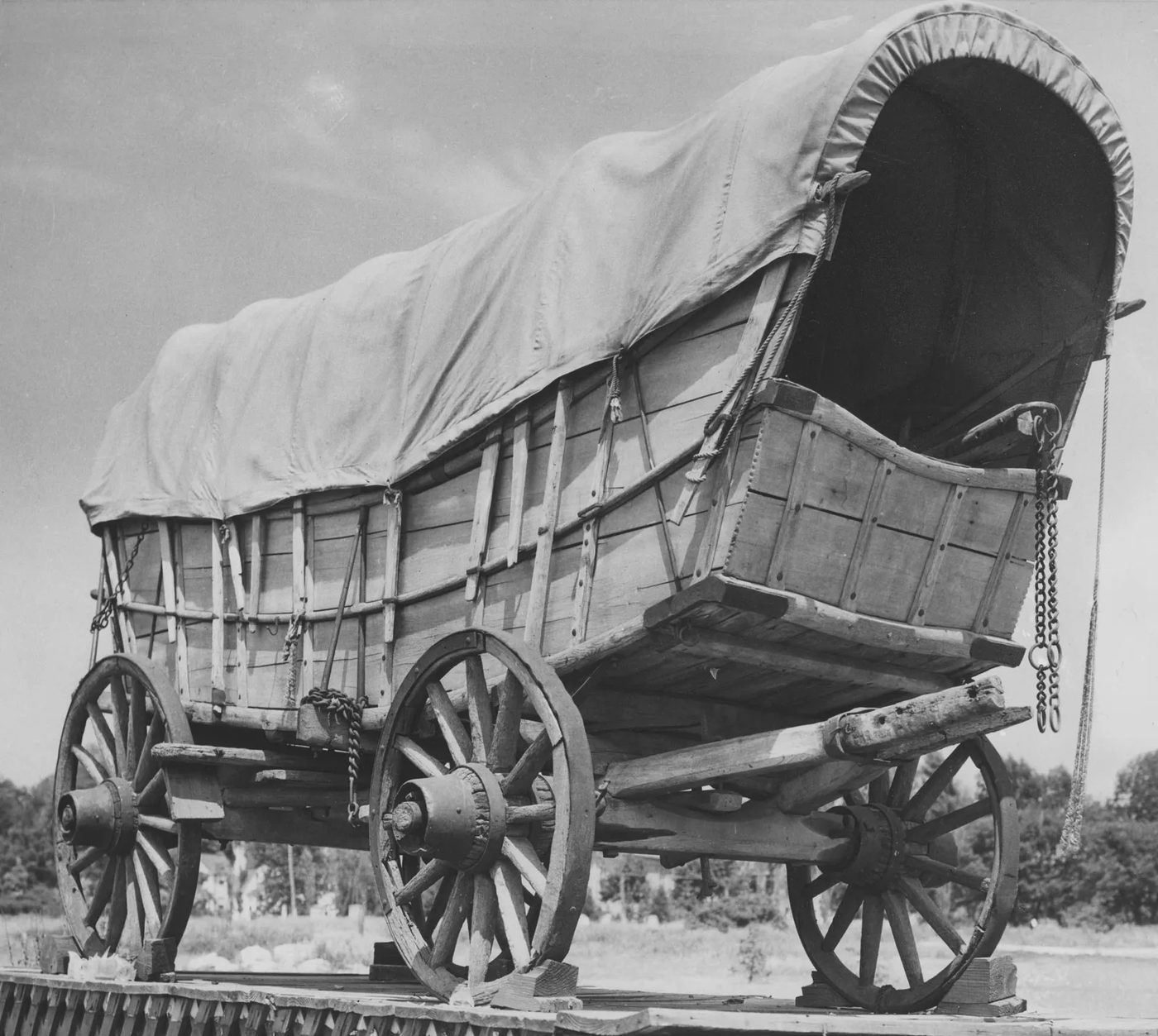 Restored Conestoga wagon, side view, showing the curved boat-shaped bed and iron-rimmed wheels